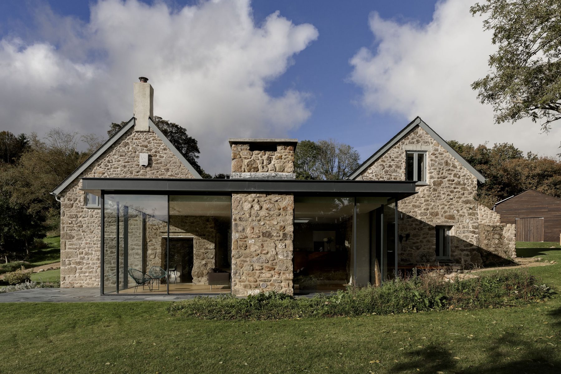 Glass box extension to granite farmhouse and barn in Dartmoor, Devon.