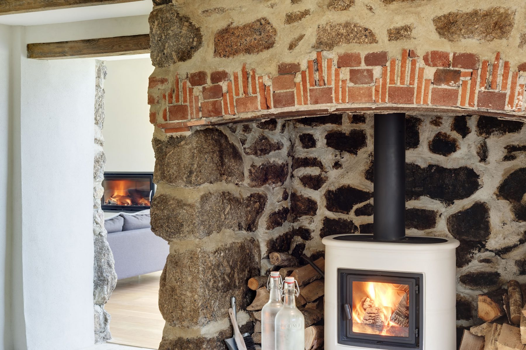 Contemporary Italian wood burner within traditional granite fireplace.
