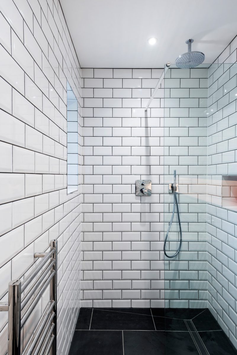 White metro tile walk in shower with matki shower screen and sanitary ware. Slate tiled floor.