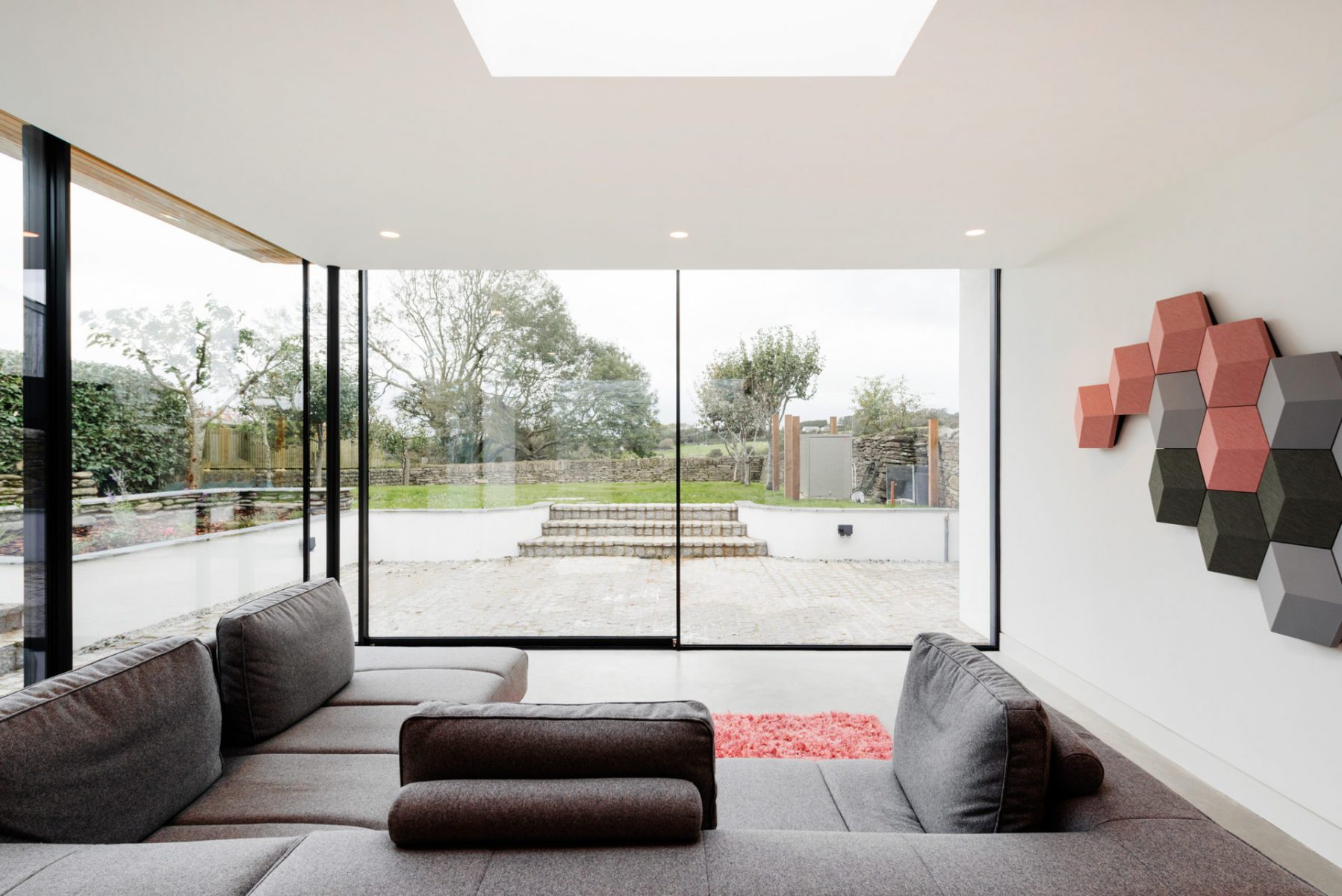 Glass extension with polished concrete floor and flat roof lights