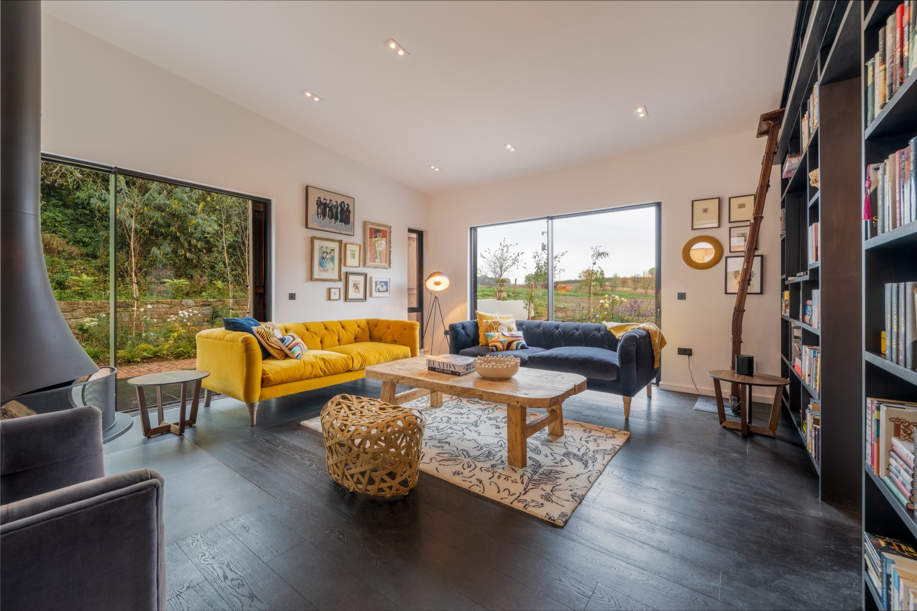 View of a living room with yellow sofa, coffee table and built in bookshelf