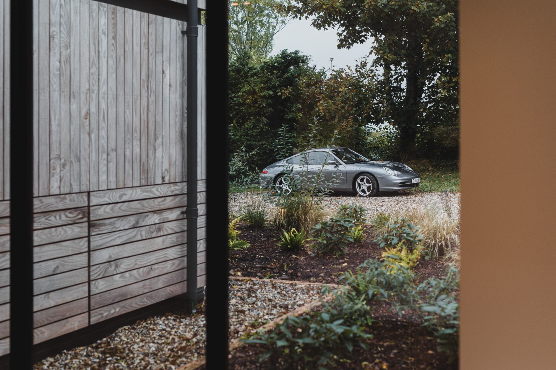 View of the Higher Dorsley driveway from inside with a grey Porsche in the driveway