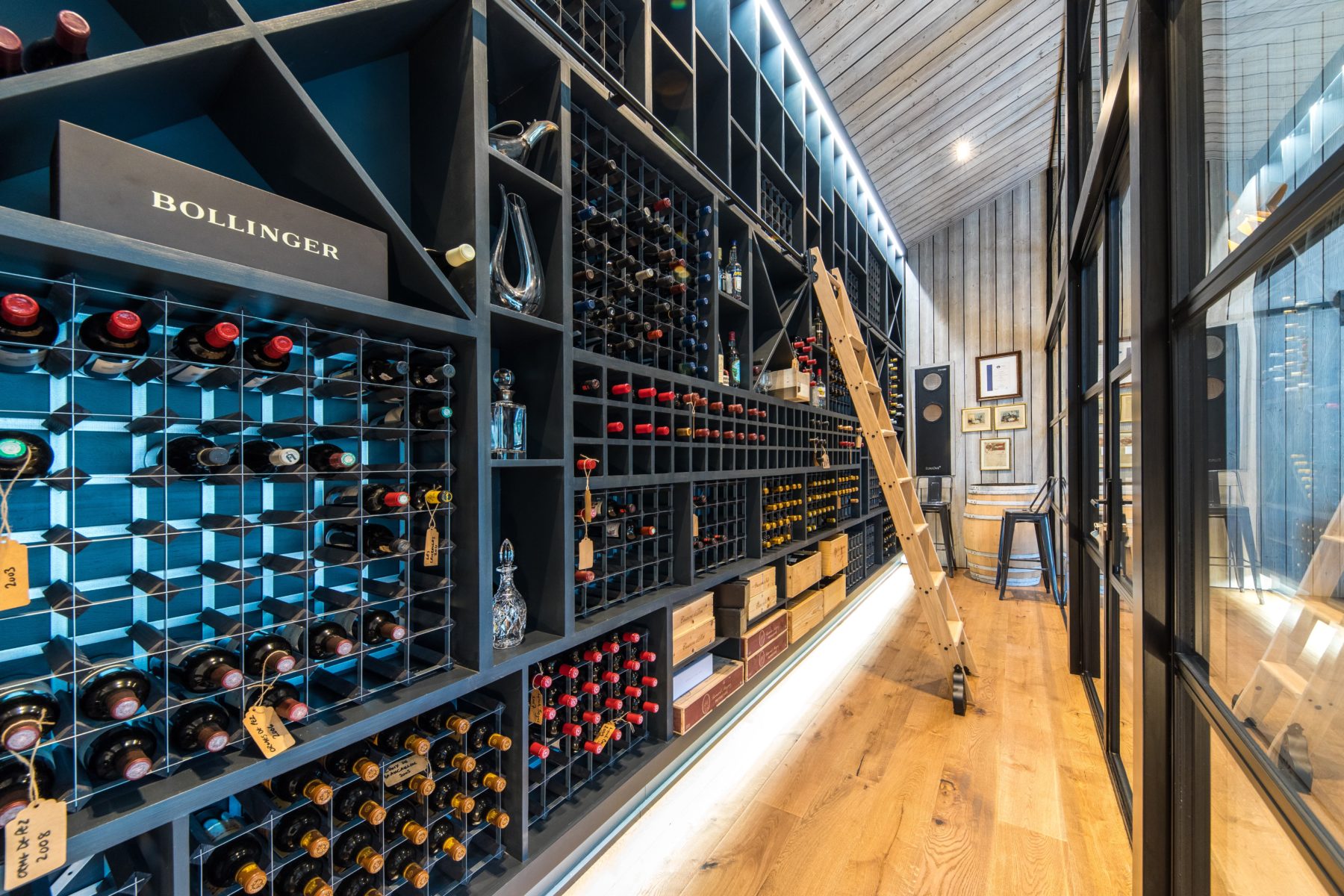 Luxury built in wine cellar with glass panels and ladder