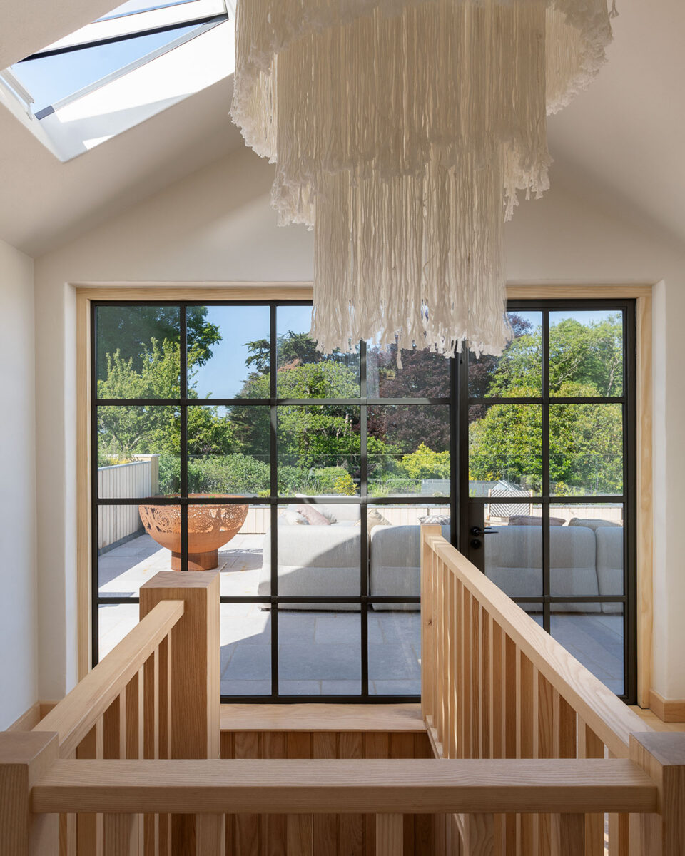 Feature light fitting above spiral staircase, and crittall screen on landing, VESP architects, Dorset