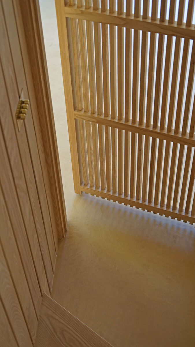 Hidden door in joinery wall at the bottom of spiral staircase, VESP architects, Dorset