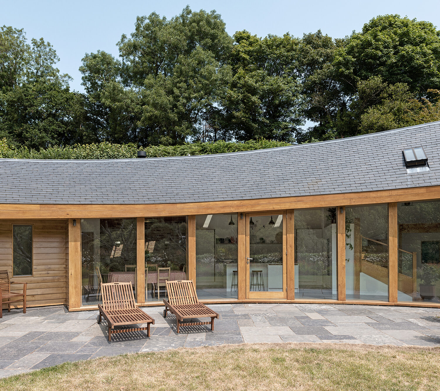 Curved Oak Listed Building Extension in South Hams Devon - External photograph showing building and garden